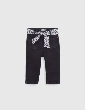 Baby girl jeans with floral belt-scarf trim.