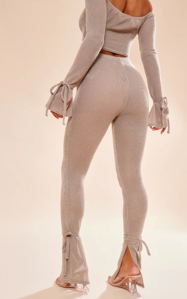 Gray stone transparent ribbed leggings with slit hem and bow detail.