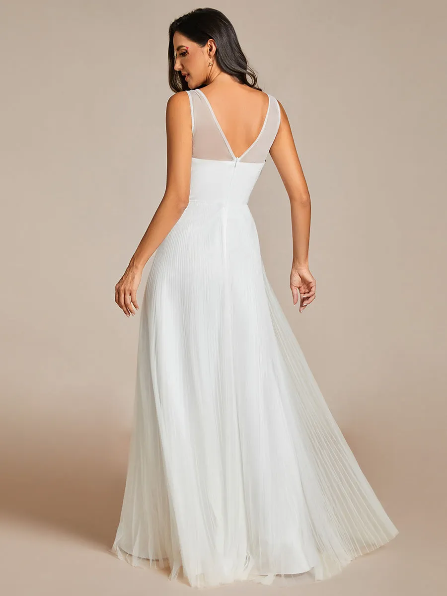 Tulle trapeze evening gown with sleeveless bodice and exquisite appliqué embroidery.