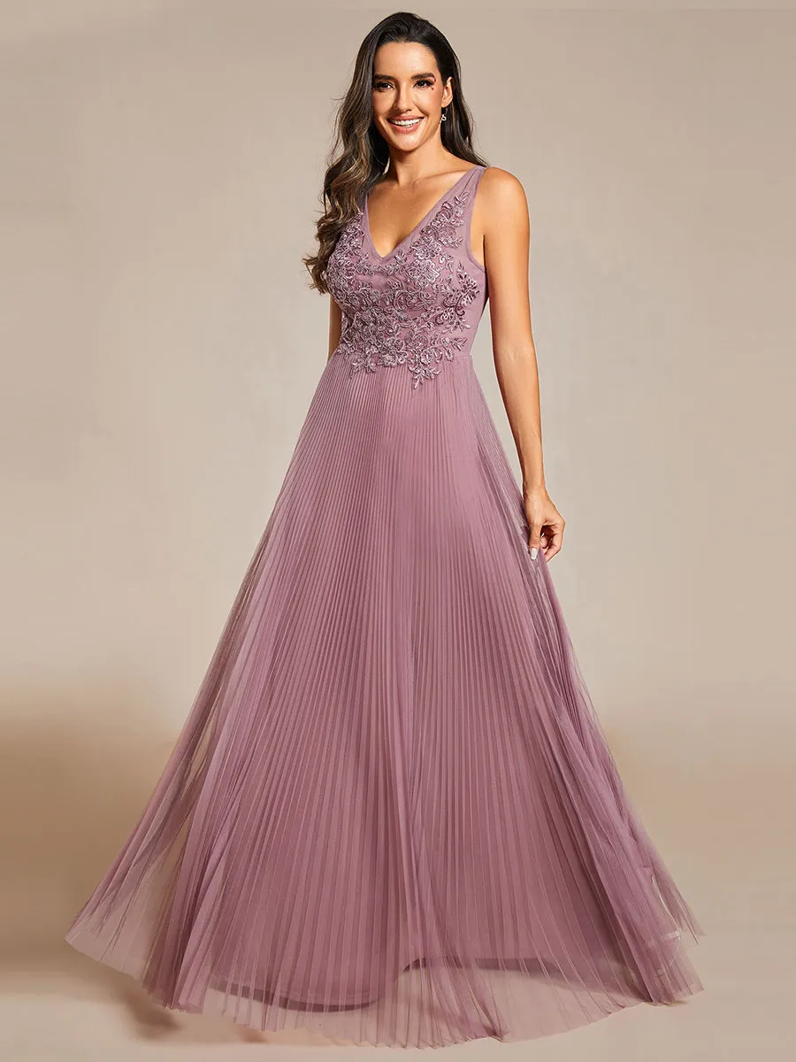 Tulle trapeze evening gown with sleeveless bodice and exquisite appliqué embroidery.